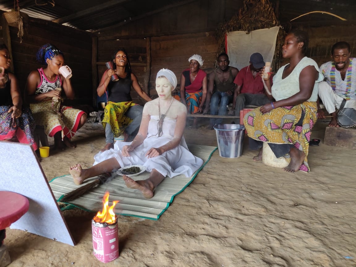 A traditional Bwiti iboga ceremony — participants seated in a wooden temple around the fire